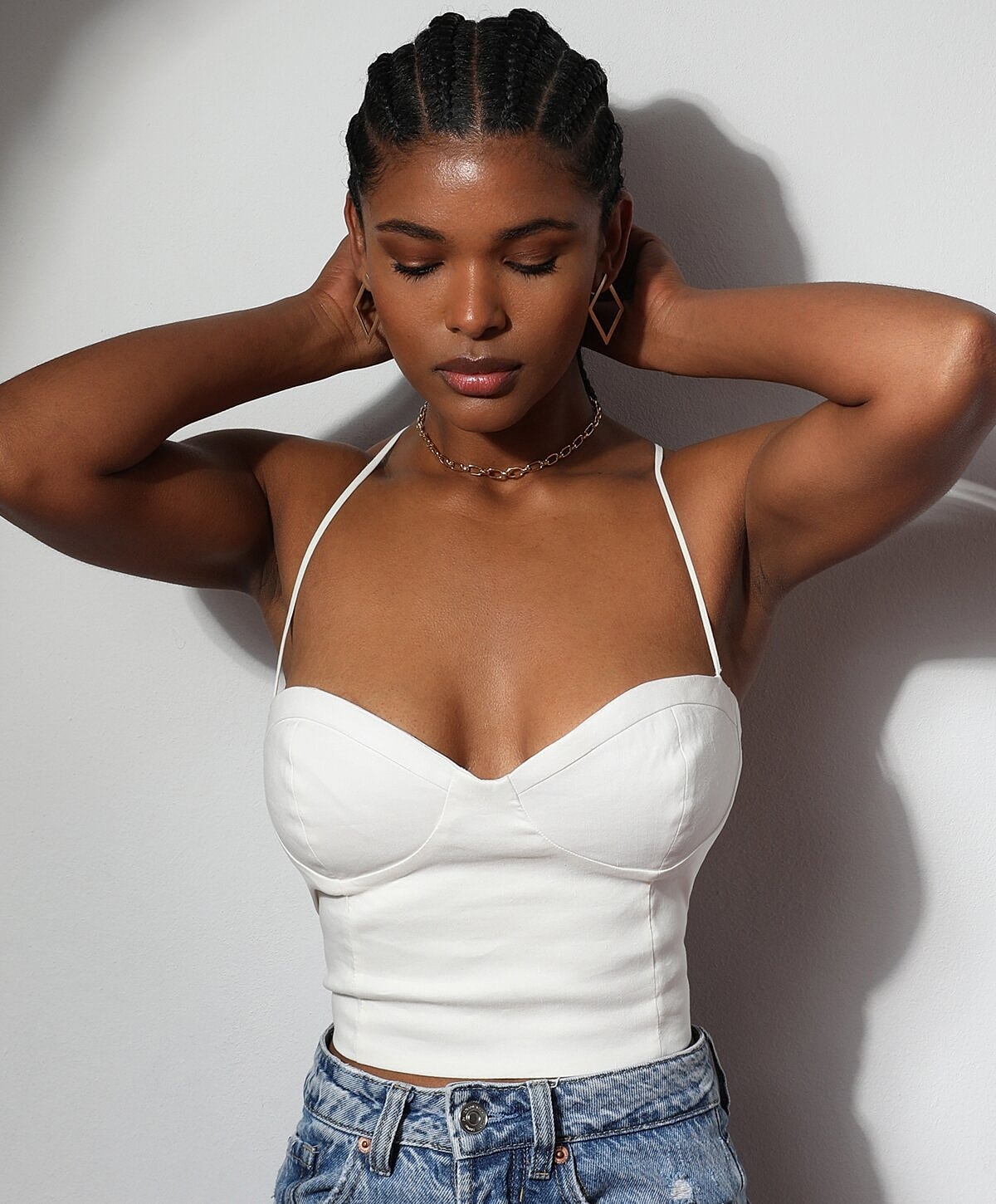 Woman in white top with braided hair.