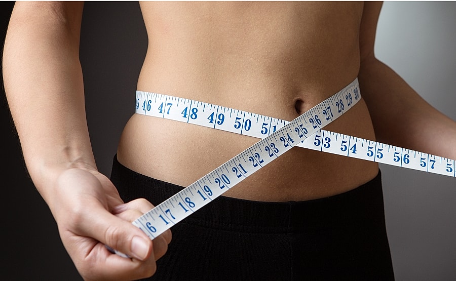 Model wearing black shorts against a gray background.