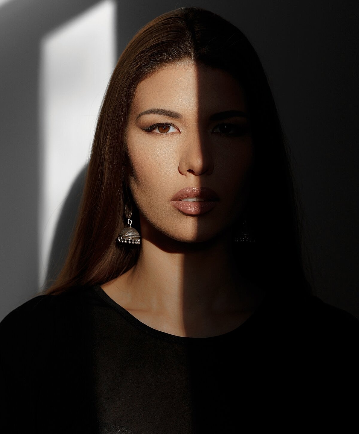 Model striking a pose against a textured wall.