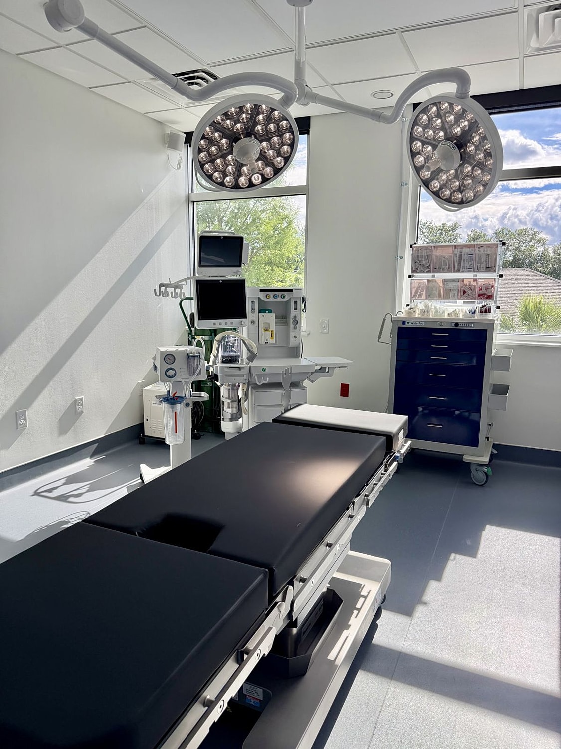 Surgical room with medical equipment and lighting.