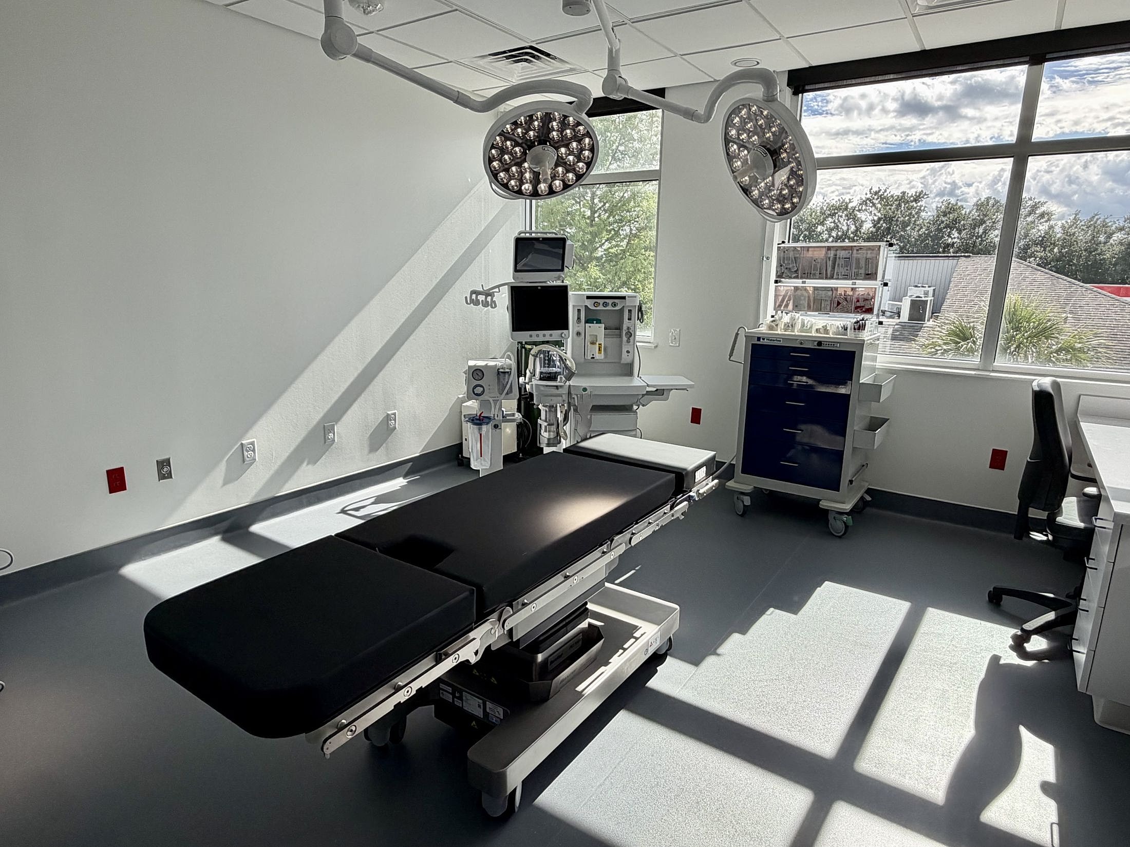 Modern surgical room with medical equipment and lighting.