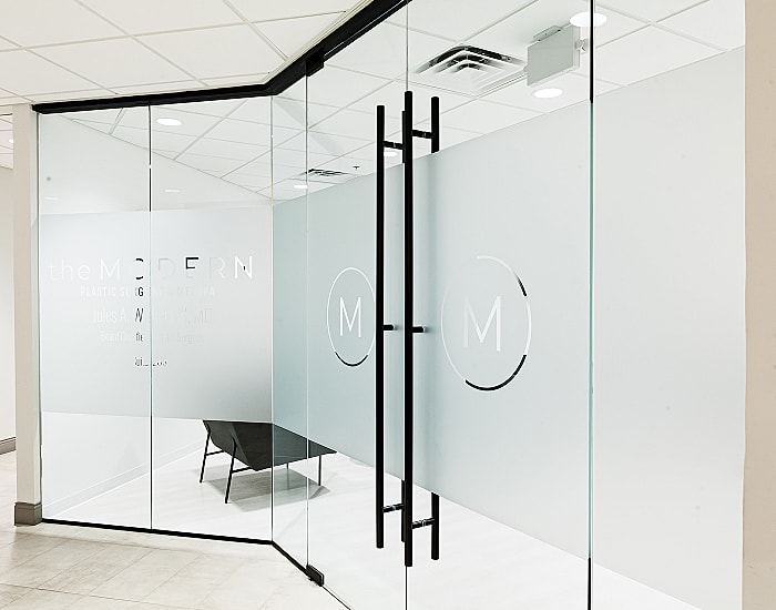 Modern glass office entrance with logo.