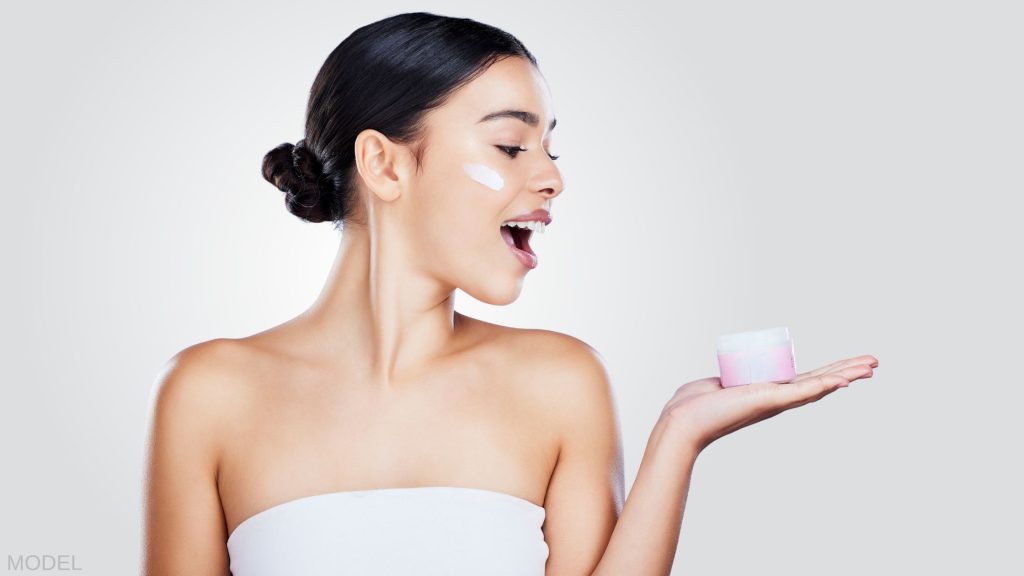 Woman smiling and holding a jar in her hand. (MODEL)